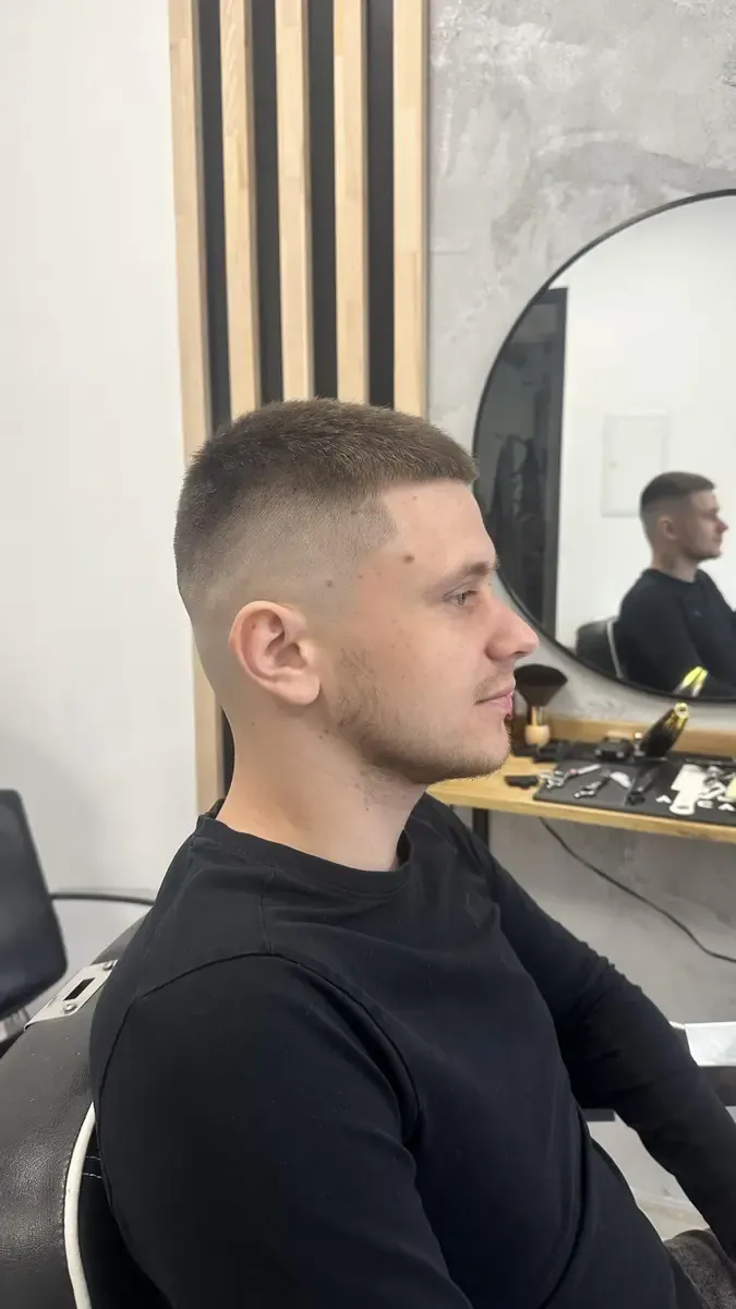 Krótkie męskie strzyżenie z równą górą i czystym przejściem fade po bokach