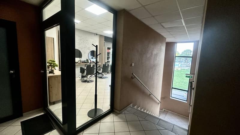 Wejście do ALIA Barber od strony klatki schodowej z widokiem na wnętrze salonu